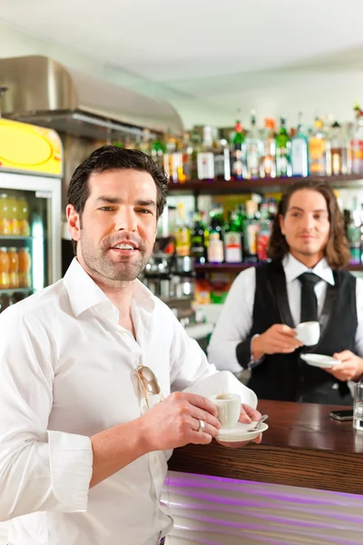 Barista con cliente nel suo caffè o caffetteria — Foto Stock