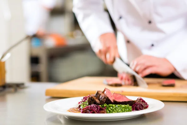 Koch in Restaurantküche bereitet Essen zu — Stockfoto