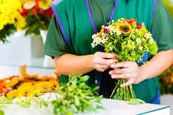 Vrouwelijke bloemist in bloemenwinkel — Stockfoto