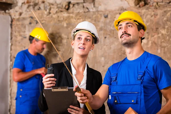 Bauarbeiter und Architekt diskutieren auf Baustelle — Stockfoto
