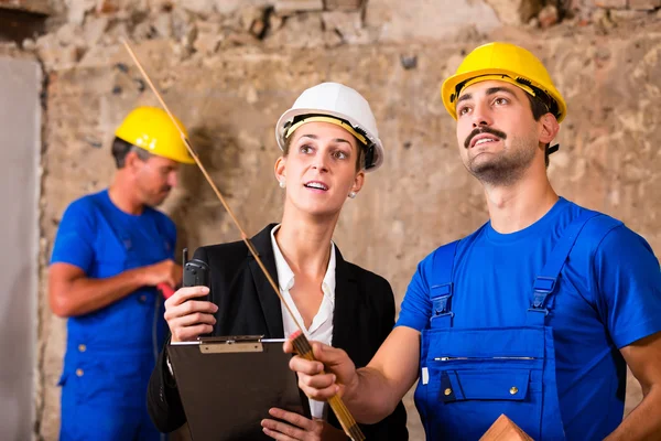 Construtor e arquiteto discutindo no canteiro de obras — Fotografia de Stock