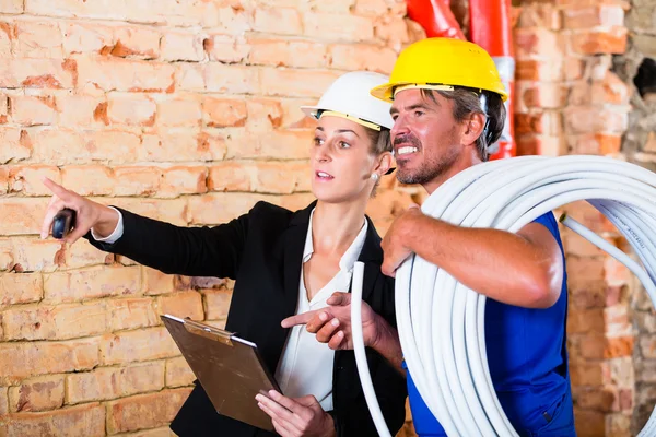 Builder and architect working on construction site — Stock Photo, Image