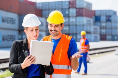 Shipping company workers in front of containers