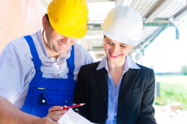 Construction Team with building plans on site