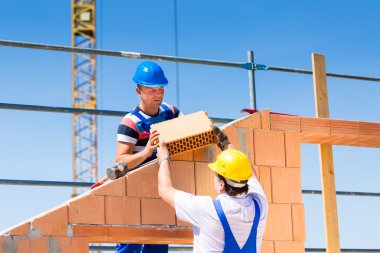 Bricklayer or builders on construction site working
