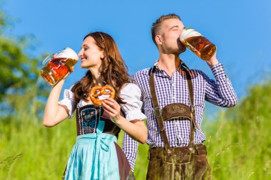 Bira ve çubuk kraker ile Tracht Alman çift