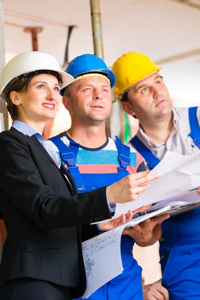 Work Team controlling floor plan — Stockfoto