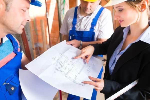 Work Team on controlling floor plan — Stock fotografie