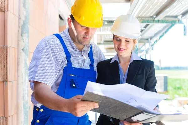 Equipo de construcción con planos de construcción en el sitio — Foto de Stock