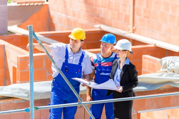 Team discussing construction or building site plans — Stockfoto