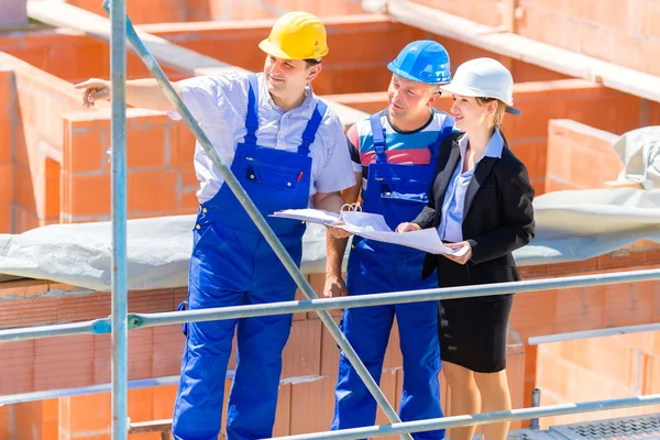 Team discussing construction or building site plans — Stockfoto