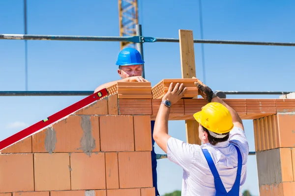 Bricklayer or builders on construction site working — 图库照片