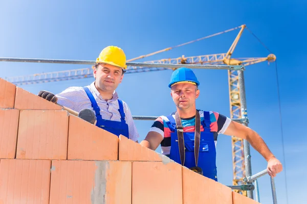 Construction site workers building house with crane — Stock fotografie