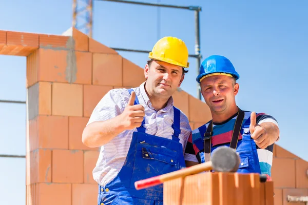 Construction site workers building walls on house — 图库照片