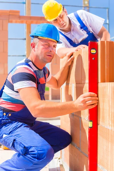 Construction site workers checking building shell — Stockfoto