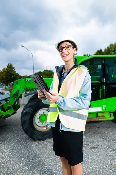 Architect in front of excavator using tablet — Stock fotografie