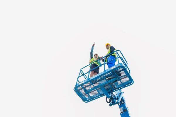 Travailleurs de la construction sur place dans la rampe de levage hydraulique — Photo