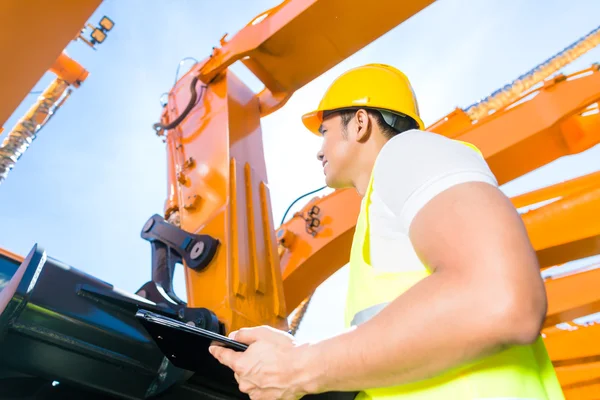 Asiatischer Ingenieur steuert Schaufelbagger — Stockfoto