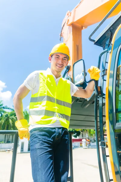 Azjatycki builder z koparki na budowie — Zdjęcie stockowe