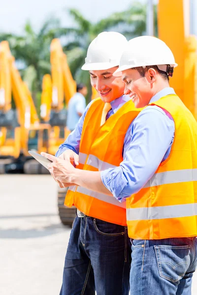 Ingenjör diskuterar planer på byggarbetsplats — Stockfoto