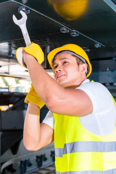 Asiatischer Mechaniker repariert Baufahrzeug — Stockfoto