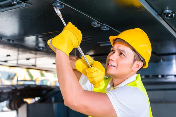 Mecánico asiático reparación de vehículos de construcción — Foto de Stock