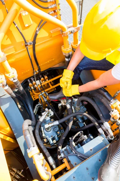 Mecánico asiático reparación de vehículos de construcción — Foto de Stock