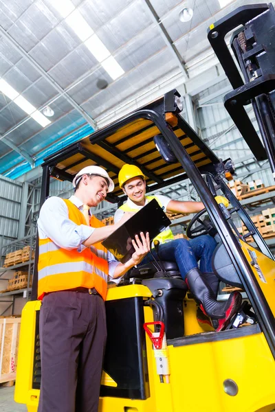 Lift vrachtwagenchauffeur en foreman in opslag — Stockfoto