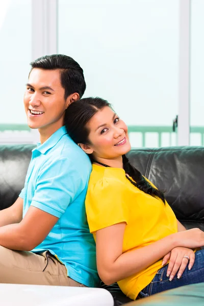 在沙发上或沙发上对亚洲年轻夫妇 — 图库照片