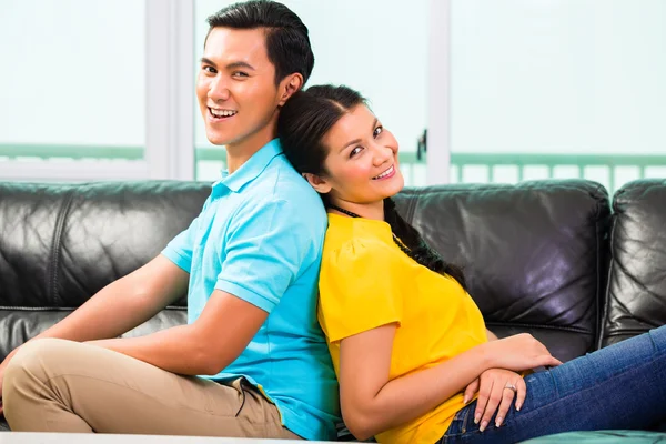 在沙发上或沙发上对亚洲年轻夫妇 — 图库照片