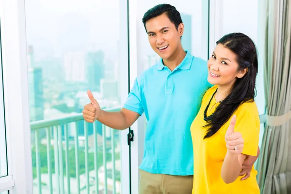 Casal olhando pela janela do apartamento — Fotografia de Stock