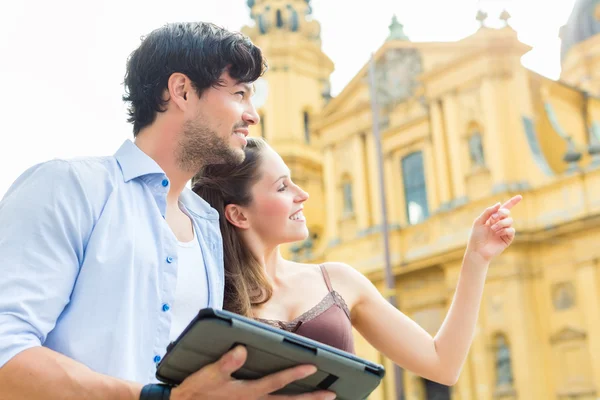 Jeunes touristes en ville avec tablette — Photo