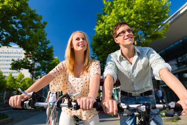 Urban couple riding bike in city