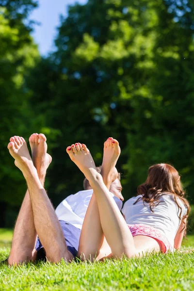 Друзі лежать з перехрещеними ногами в парку — стокове фото