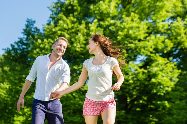 Pareja enamorada corriendo por el parque —  Fotos de Stock