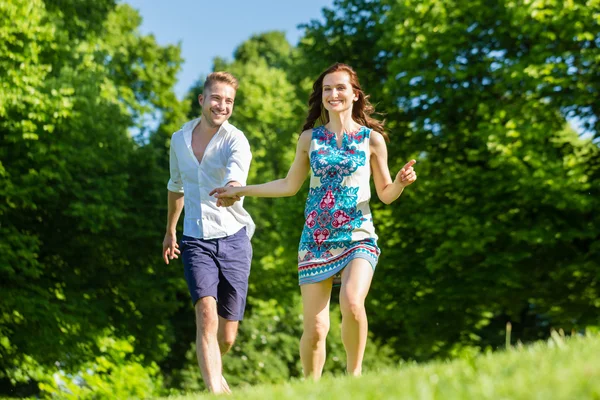 Pareja enamorada corriendo por el parque —  Fotos de Stock