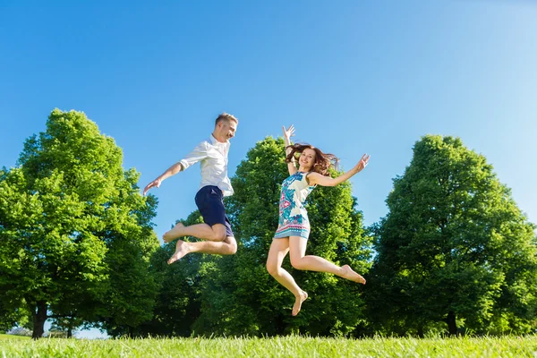Verliebtes Paar springt auf Parkrasen — Stockfoto
