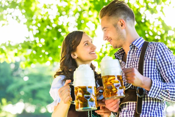 Duitse paar in klederdracht bier drinken — Stockfoto