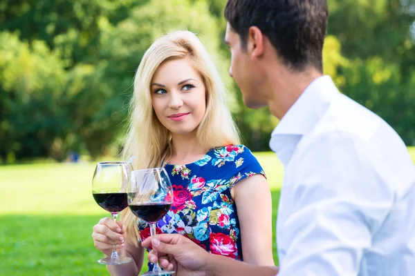 Casal beber vinho na grama do parque — Fotografia de Stock