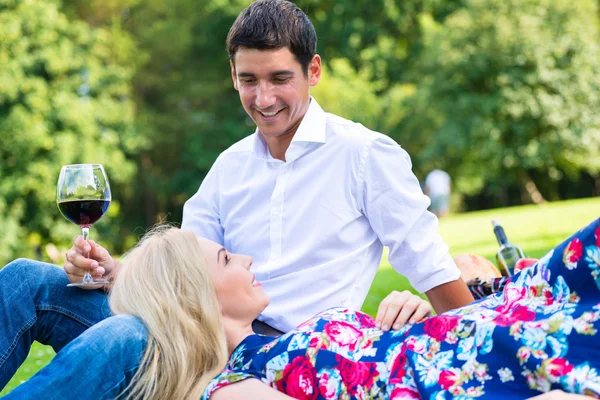 Couple boire du vin sur l'herbe du parc — Photo