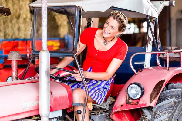 Bavarian woman driving tractor — Stock Photo, Image