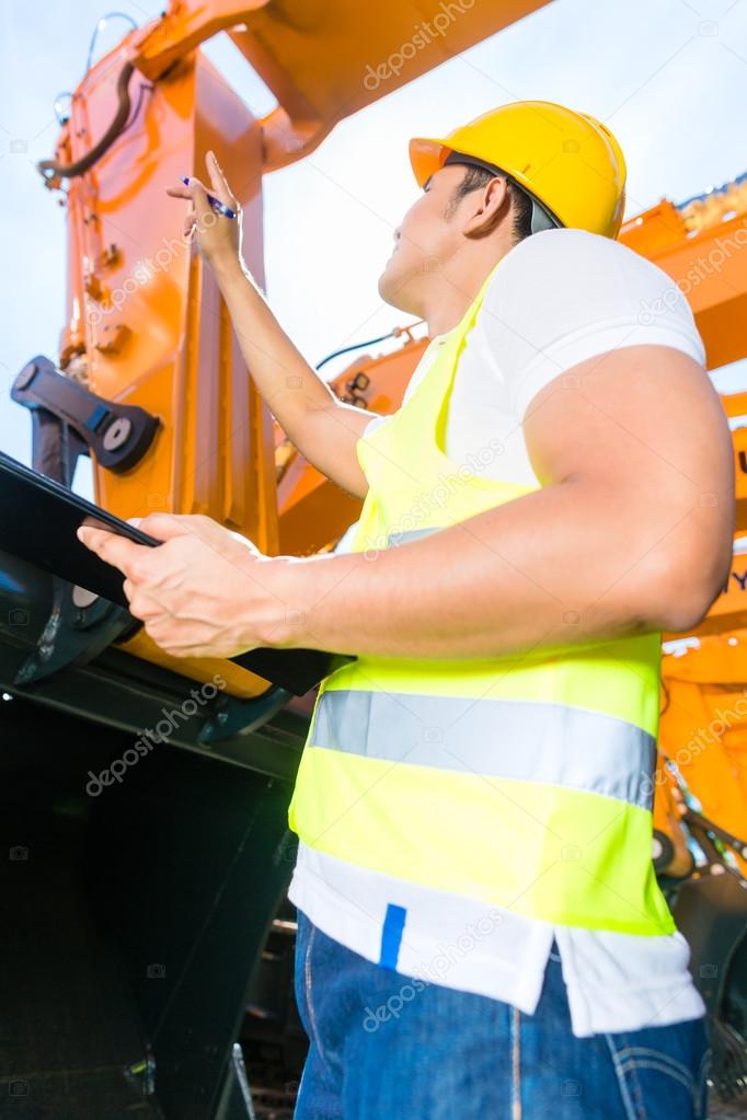 Asian engineer controlling shovel excavator 