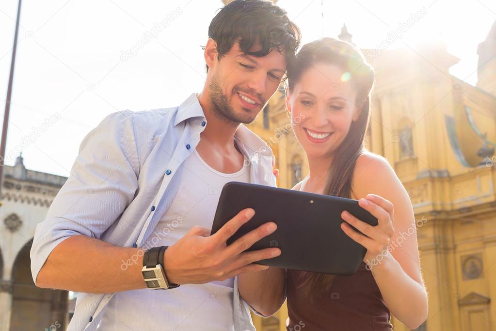 Young Tourists in city with tablet computer