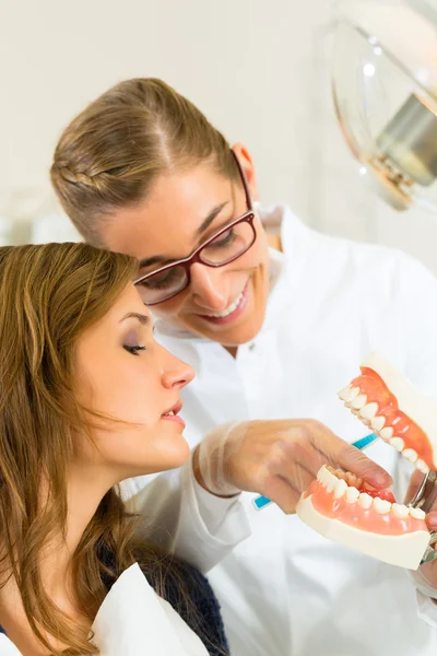 Dentista com escova de dentes, prótese e paciente — Fotografia de Stock