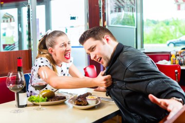 Couple eating and drinking in fast food diner clipart