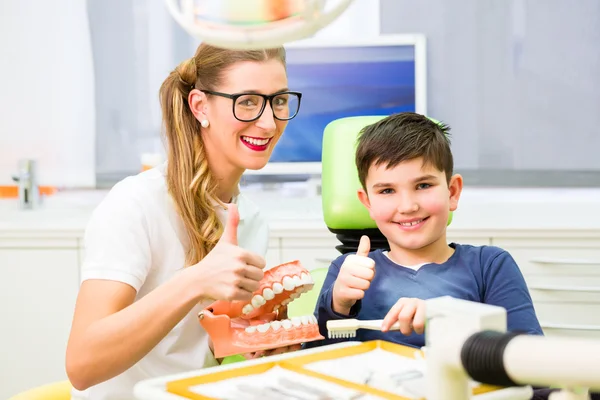 Zahnarzt erklärt Jungen beim Zähneputzen — Stockfoto