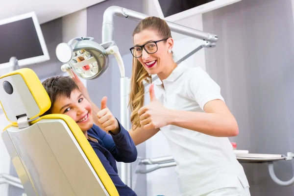 Dentista dando conselhos de menino em cirurgia dentária — Fotografia de Stock