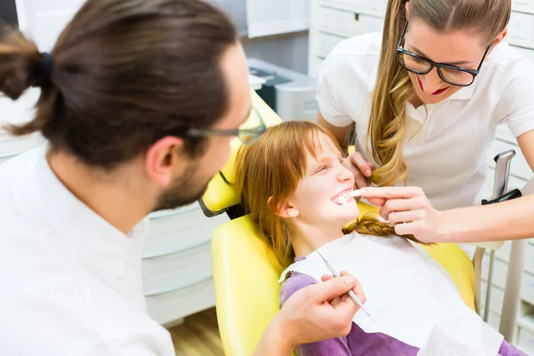 Dentista che dà trattamento ragazza in chirurgia dentale — Foto Stock