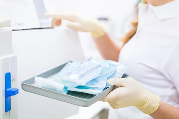 Assistente com ferramentas odontológicas estéreis — Fotografia de Stock