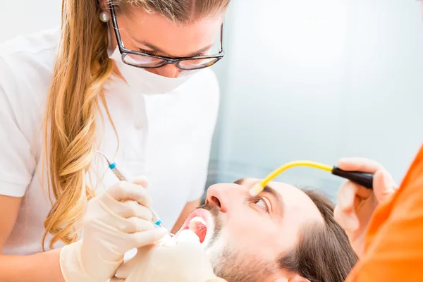Пацієнт має глибоке чищення зубів у стоматолога — стокове фото